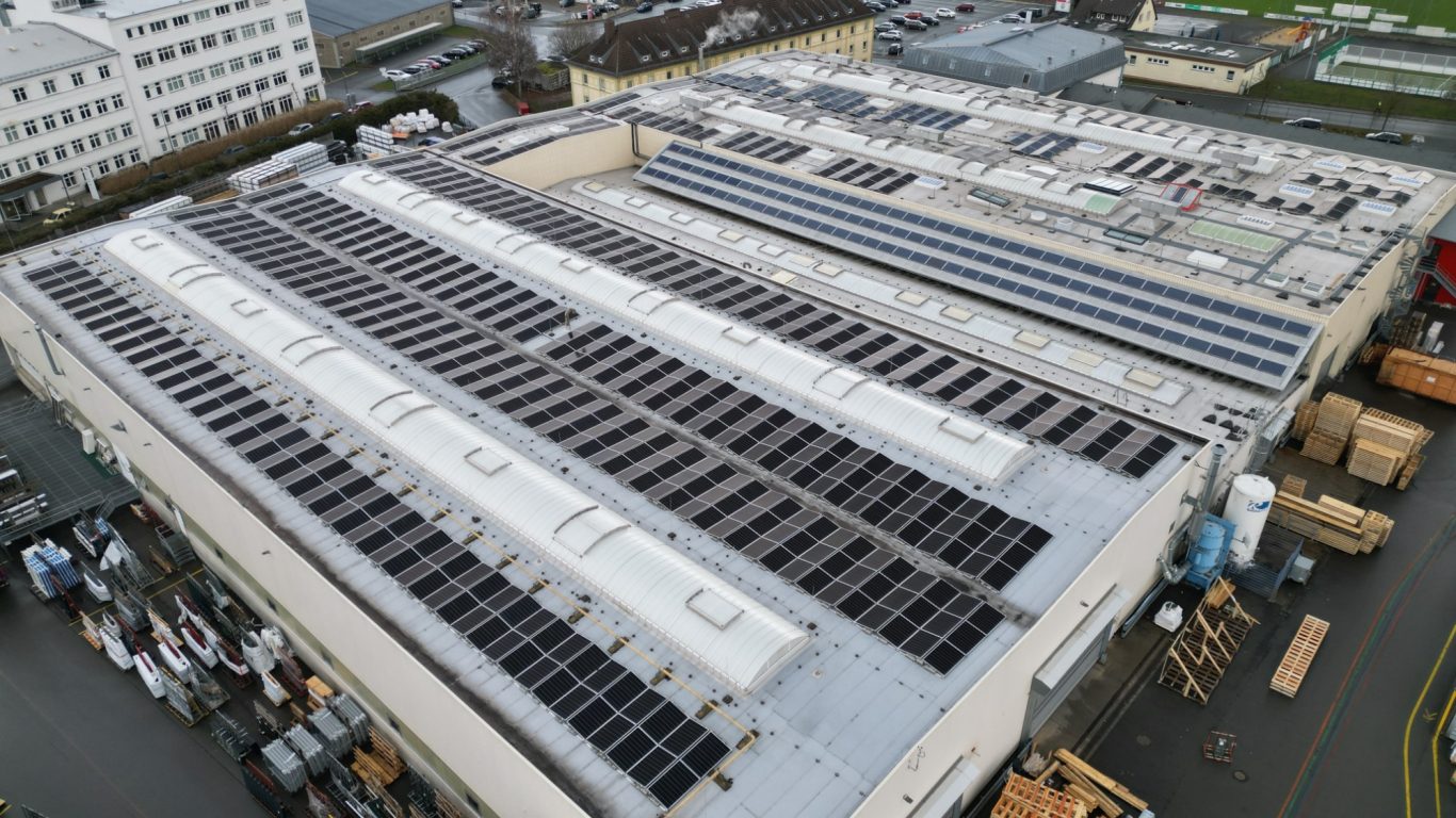 451 kWp Anlagenleistung Dachansicht eines Industriegebäudes mit Photovoltaikanlagen auf der Oberfläche.